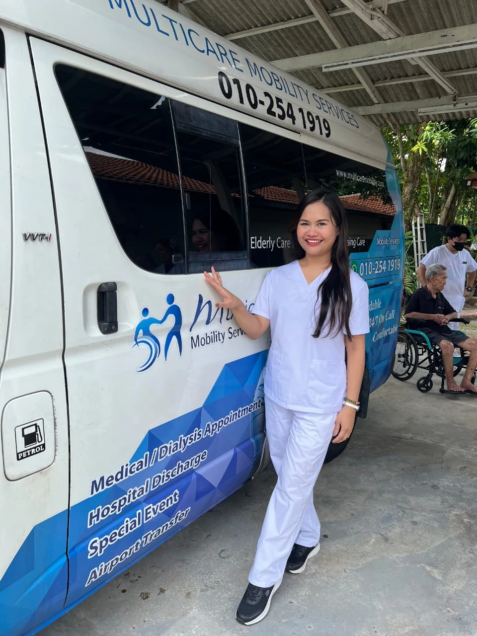 Multicare caregiver beside a branded mobility van
