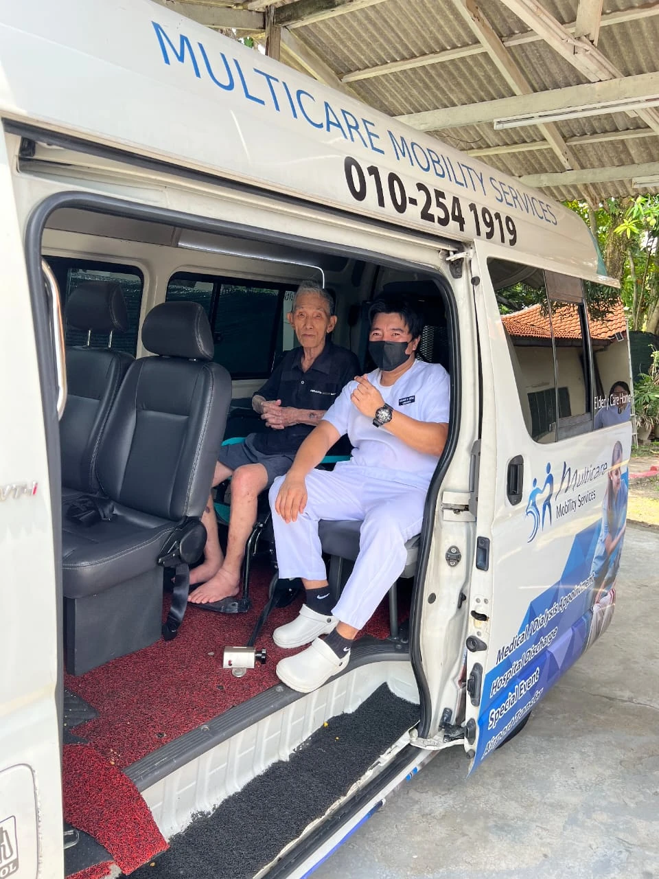 Multicare team supporting a passenger inside a wheelchair-accessible mobility van
