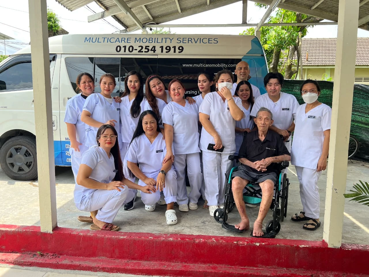 Multicare team with a wheelchair passenger beside our van